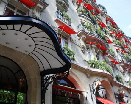 hotel exterior with red canopies in Paris