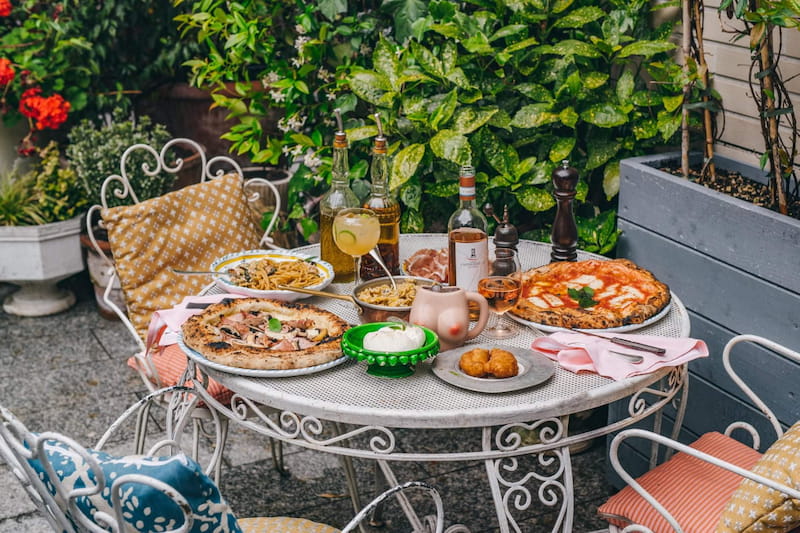 pizza and pasta served on a garden table
