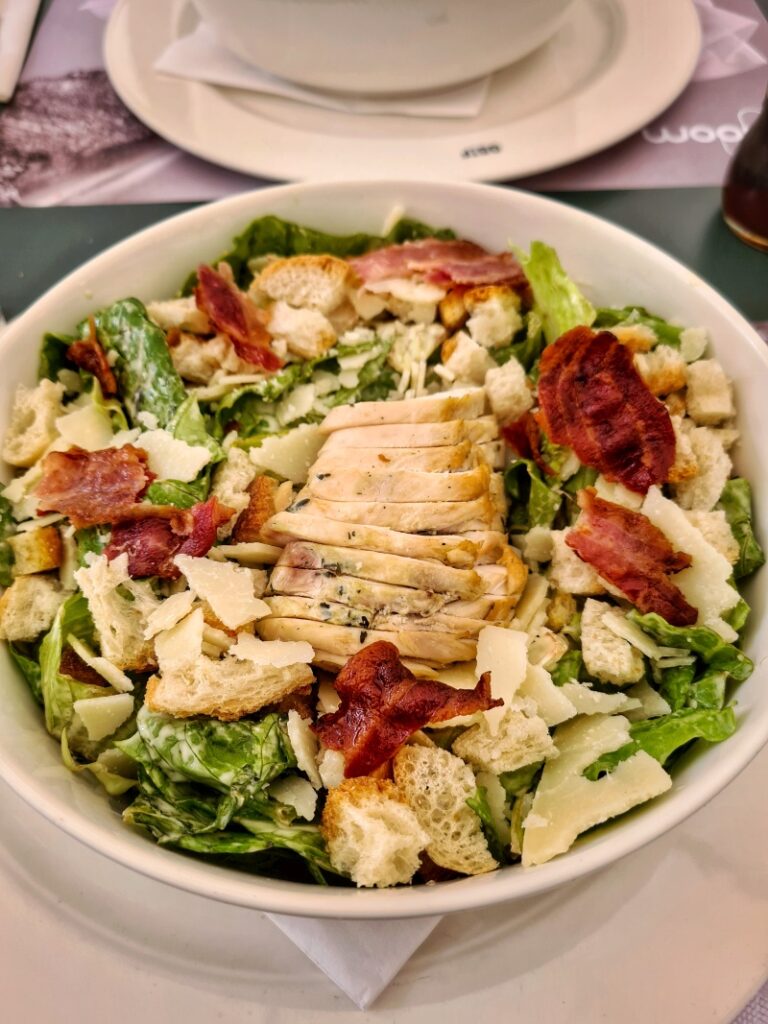 Caesar salad in a bowl on a table in a restaurant