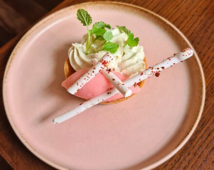 rhubarb dessert on a pink plate on a wooden table