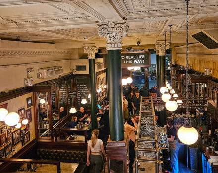 interior of a restaurant with a decorative ceiling and hanging lamps